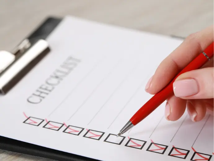 Femme remplissant une liste de contrôle à une table en bois, gros plan